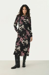 Rochie neagră cu mâneci lungi, cu un design floral în nuanțe de roz și crem. Are un tăiat până la genunchi și două buzunare laterale, fiind asortată cu cizme negre.
