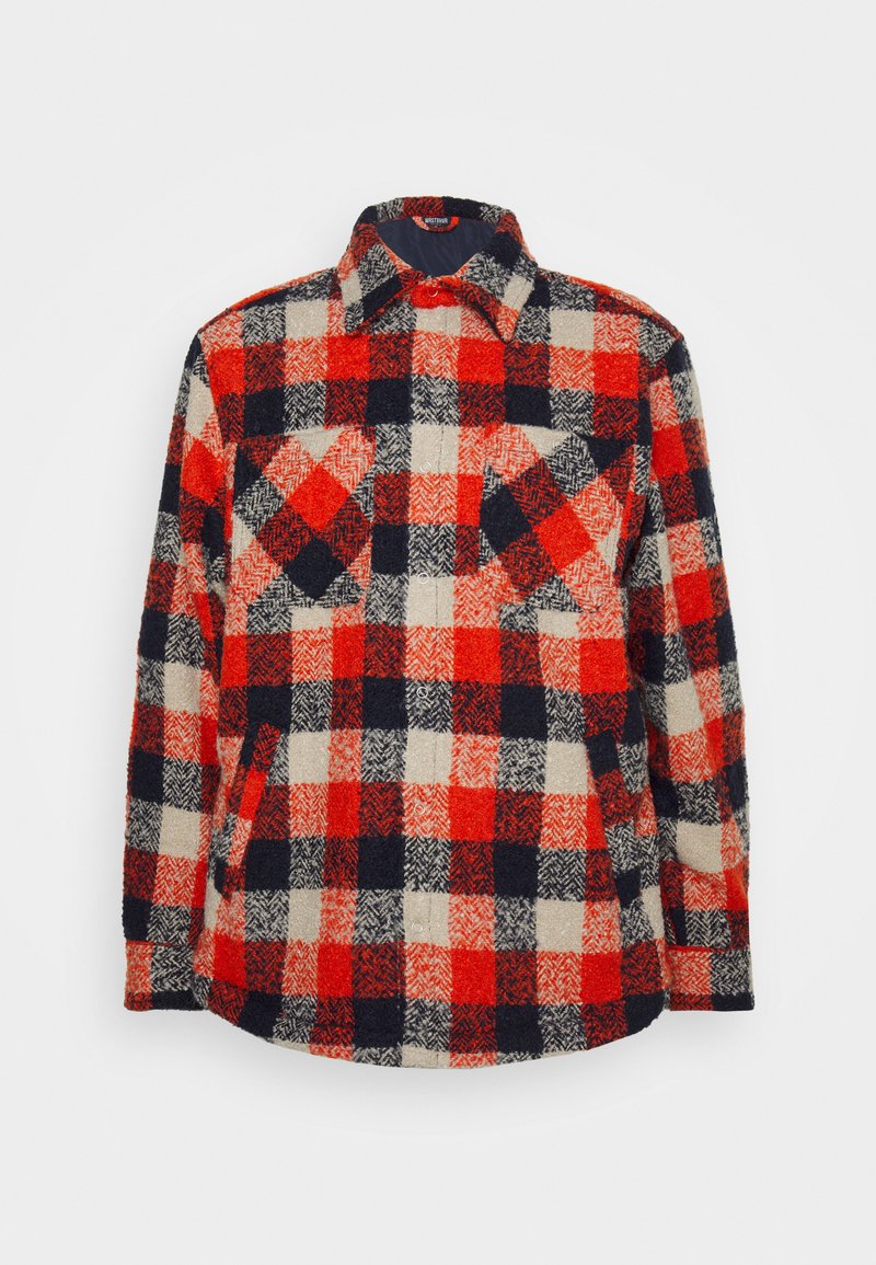 Camisa de flanela xadrez em vermelho, azul-marinho e creme, com colarinho clássico, dois bolsos no peito e fecho de botão. Tecido texturizado, aparência quente.