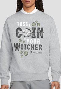 Gray sweatshirt featuring a graphic design with the text "TOSS A COIN TO YOUR WITCHER," illustrated coins, and a wolf emblem.