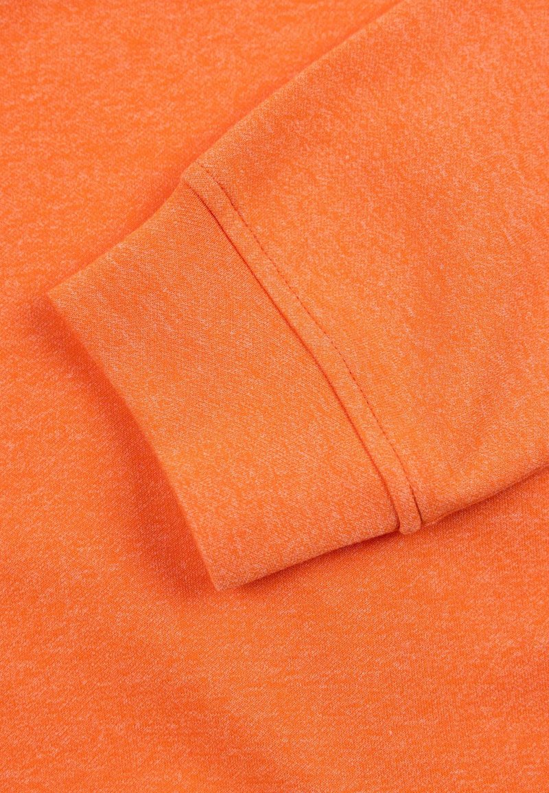 Pomarańczowy materiał o heathered fakturze, z dzianinowym zakończeniem rękawów. Tkanina wydaje się miękka i wygodna, z widocznymi detalami szwów.