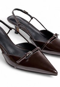 Tacchi slingback in pelle lucida marrone scuro, con punta affusolata, sottili cinghie alla caviglia e dettagli decorativi con fibbia. Fodera interna texture.