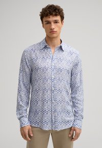 Camicia a maniche lunghe con bottoni di colore azzurro chiaro, decorata con un motivo a piccoli quadrati e diverse tonalità di blu. Tessuto di cotone.