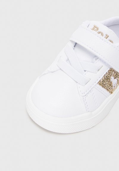 Sapatilha branca feita de material sintético texturizado. Apresenta uma fita aderente, atacadores e um detalhe de glitter dourado na lateral. Design de bico arredondado.
