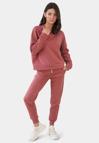 Rosa Sweatshirt und passende Jogginghosen, aus weichem Stoff, mit lässigem Schnitt, elastischen Bündchen und flachem Kordelzug.
