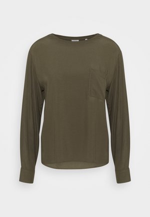 Chemise vert olive à manches longues avec col rond et poche poitrine, présentée sur un fond blanc uni.