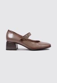 Zapato tipo Mary Jane de cuero marrón con un acabado texturizado, puntera redonda y tacón bajo. La correa con hebilla añade detalle.