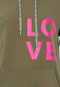 Felpa verde oliva con grande stampa rosa "LOVE" sul davanti, dotata di cordini con ripetuto testo "LOVE" e tasca a marsupio.