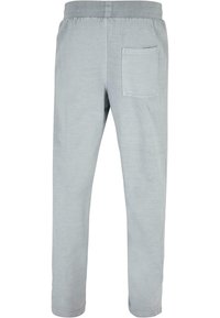 Ljusgrå sweatpants gjorda av mjukt tyg, med en elastisk midja och en enda bakficka. Rakt snitt. Inga synliga mönster.