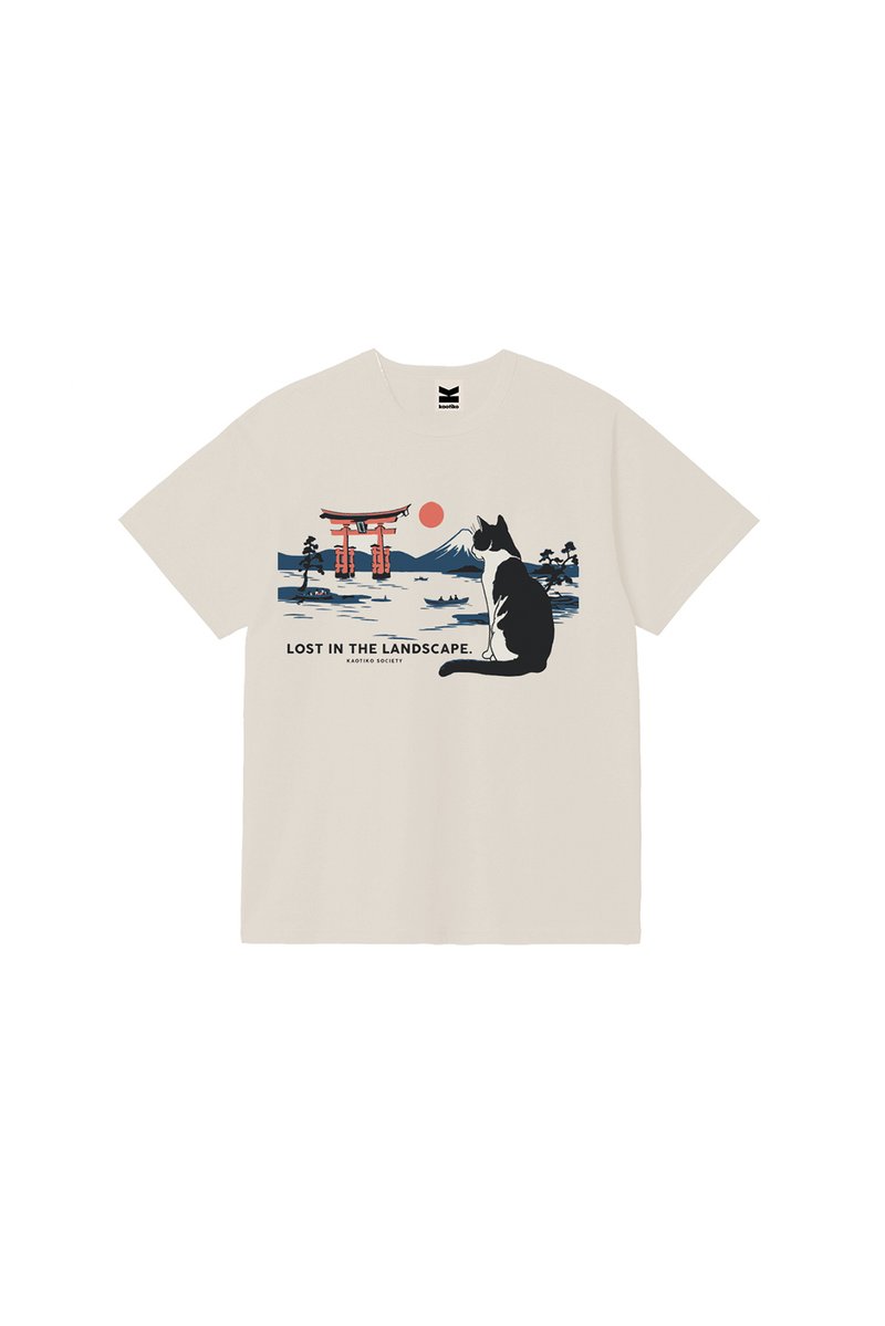 Μπεζ T-shirt με μια ασπρόμαυρη γάτα που κάθεται και κοιτάζει μια κόκκινη πύλη τορίι, βουνό και ήλιο με κείμενο «Χαμένη στο τοπίο.»