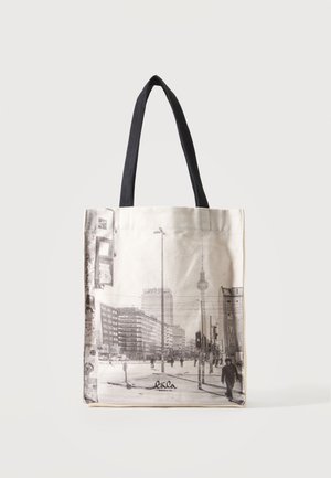 Sac cabas en toile avec des anses noires, orné d'une impression en noir et blanc d'un paysage urbain avec des bâtiments et des piétons.