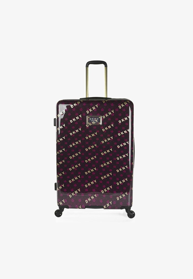 Maleta rígida negra y morada con patrón de logo de DKNY, acentos dorados, asa retráctil y cuatro ruedas para mayor movilidad.