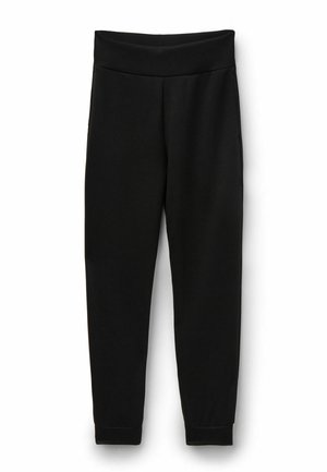 Schwarze, hochgeschnittene, zulaufende Jogginghosen mit elastischem Bund und Bündchen, aus weichem Stoff, vor weißem Hintergrund dargestellt.