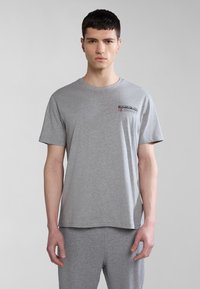 Camiseta gris de manga corta hecha de una mezcla de algodón. Presenta un pequeño logo en la parte izquierda del pecho, corte relajado y cuello redondo.