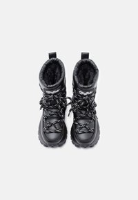 Pár černých zimních bot značky Buffalo s tlustými podrážkami, vzorovanými tkaničkami a měkkou vnitřní podšívkou, pohled zeshora na bílém pozadí.