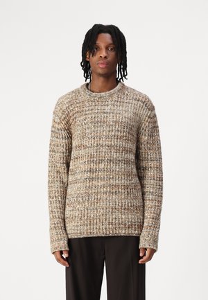 Pull en tricot texturé beige avec des accents marron, doté d'un col rond et de manches longues, fabriqué à partir d'un matériau doux et chaud.