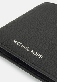 Black leather wallet featuring a textured finish. The brand name "MICHAEL KORS" is embossed in silver on the front.