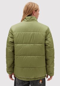 Chaqueta acolchada verde oliva con cuello alto, con secciones acolchadas y dobladillo elástico, vista desde la parte de atrás.