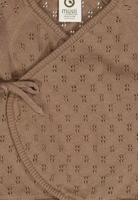 Top avvolgente a maglia marrone con scollatura a V, caratterizzato da un motivo testurizzato di piccoli fori e chiusura annodata sul lato. Etichetta del brand visibile.