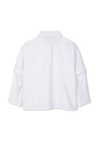 Camisa blanca de manga larga con cuello clásico, puños abotonados y corte recto. La tela parece suave y sin patrones visibles.