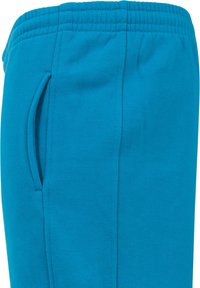 Pantaloni de trening turcoaz cu un braț elastic, buzunar lateral și o textură de țesătură netedă, având cusături întărite pentru durabilitate.