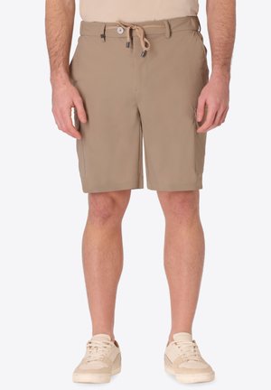 Uomo che indossa pantaloncini beige fino al ginocchio con coulisse e bottone, abbinati a sneakers beige chiaro, in piedi con le braccia rilassate lungo i fianchi.