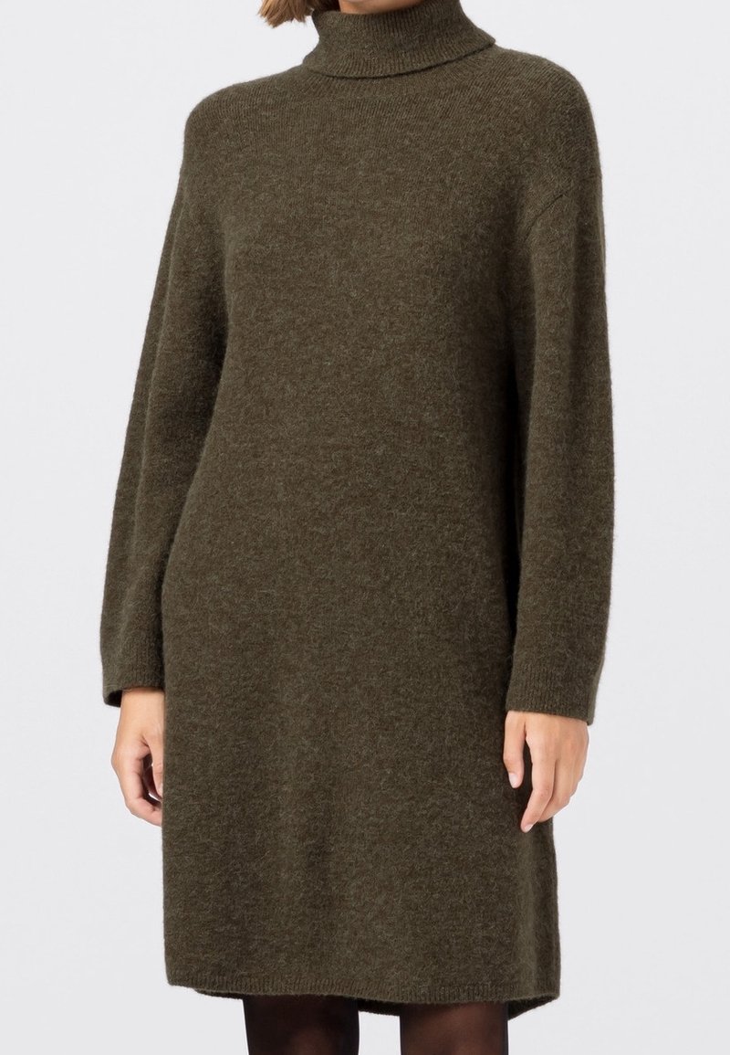 Robe tricotée vert olive avec un col roulé haut, des manches longues et une coupe décontractée, présentant une texture douce et atteignant mi-cuisse.