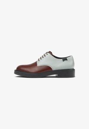 Zapatos de cuero marrón y azul claro con puntera redonda, cinco ojales y suela de goma negra gruesa. Textura suave y colores contrastantes.