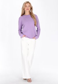 Lila geribbelde gebreide trui met een gestructureerd ontwerp, gecombineerd met witte, hooggetailleerde, wijde broekspijpen en neutrale open-toe hakken.