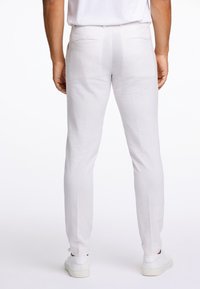 Světlé šedé lněné kalhoty s úzkým střihem, dvěma zadními kapsami, hladkou texturou a zúženým střihem nohavic.