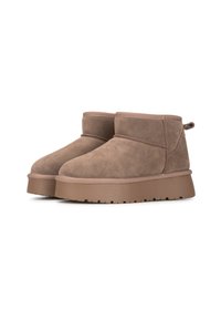 Botas tobilleras de ante marrón con puntera redondeada, un pequeño tacón y una suela texturizada. Cuentan con un forro suave y una lengüeta en la parte posterior.