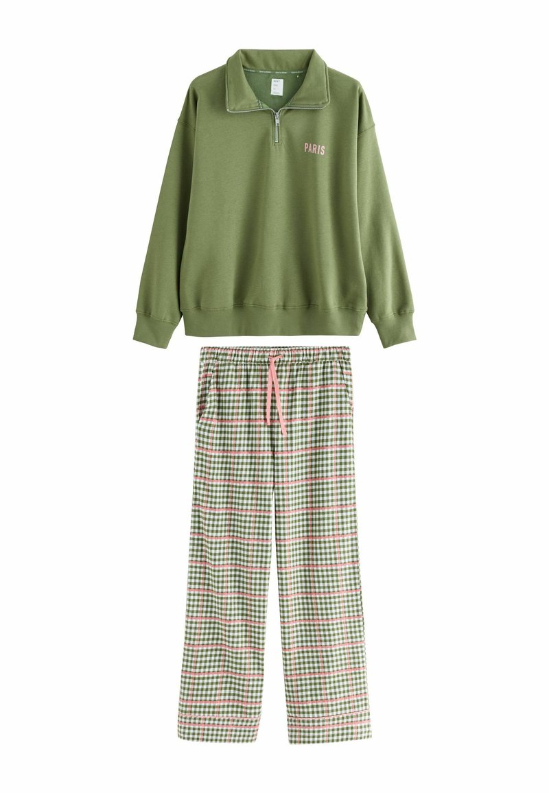 Green zip-up sweatshirt with "PARIS" text; paired with plaid pajama pants featuring green, white, and pink check patterns.