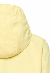 Jasnożółta kurtka z kapturem widziana od tyłu, podkreślająca przymocowany kaptur i gładką teksturę materiału.