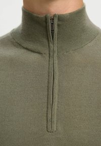 Pull olive vert à col zippé en tissu tricoté lisse ; doté d'un col montant et d'une fermeture éclair avant, avec une silhouette ajustée.