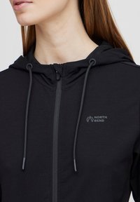 Black zip-up hoodie made from soft fabric, featuring a drawstring hood and a small, subtle “NORTH BEND” logo on the chest.