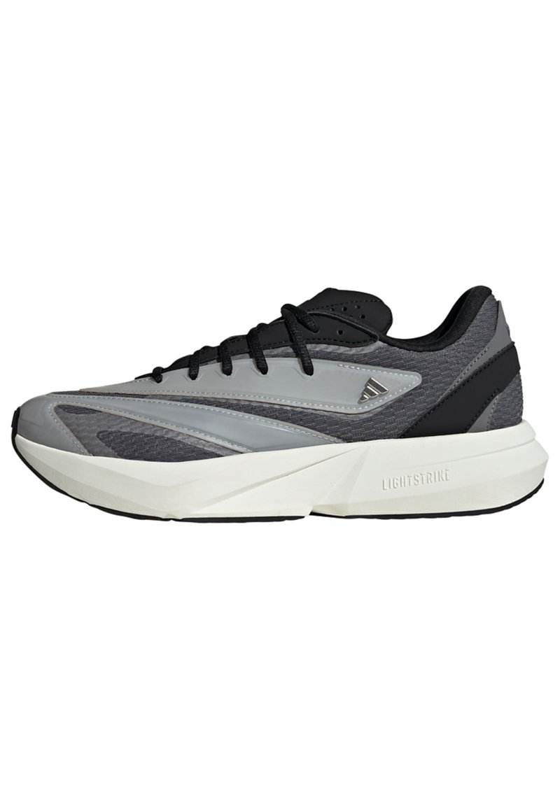 Buty sportowe w kolorze szarym i czarnym, charakteryzujące się eleganckim designem, gładką syntetyczną cholewką, siateczkowymi akcentami i lekką piankową podeszwą środkową oznaczoną "LIGHTSTRIKE."