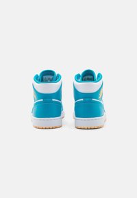 High-top sneakers in bright turquoise with white accents, featuring a rubber sole and textured leather upper. Gold logo detail on the side.