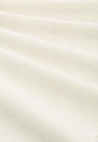 Textil cu o textură moale, cu nervuri, de culoare crem deschis, având linii paralele subtile care creează un model ondulat.