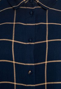Navy blue button-up shirt made of woven fabric, featuring a beige checked pattern, a classic collar, and pearlescent buttons.