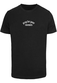 Black cotton t-shirt with short sleeves, featuring white text that reads "pray for your enemies" in a stylized font across the chest.