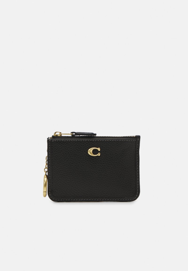 Portafoglio in pelle nera con texture, emblema dorato a forma di lettera "C", chiusura con zip e attacco laterale a catena. Presenta bordi cuciti per un dettaglio raffinato.