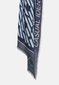 Niebieski i jasnoniebieski szalik w wzory z sylwetkami ryb, napis "CASUAL IDENTITY", frędzlowe krawędzie i wzór w diagonalne paski.