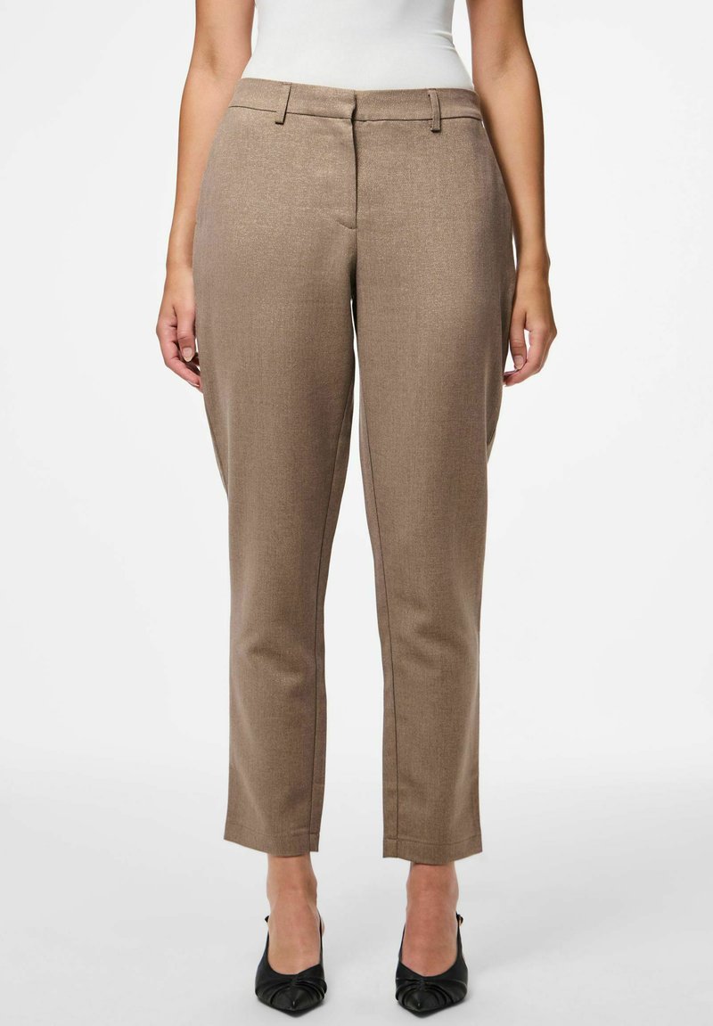 Brune skræddersyede bukser med en glat tekstur, slim fit, lige ben og diskret detaljering langs sømmene, parret med sorte spidse sko.
