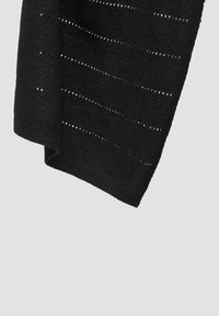 Châle noir en tricot avec un design texturé comportant des rayures horizontales et des détails ajourés le long des bords du tissu.