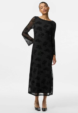 Vestido largo de encaje floral negro con mangas largas y escote barco. Detalles de encaje transparente en los dobladillos de las mangas. Forro interno suave.