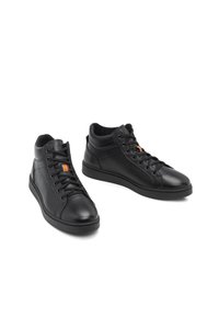 Baskets montantes en cuir noir avec lacets et un petit détail rayé orange sur la languette, présentées côte à côte sur un fond blanc.
