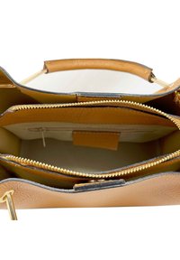 Borsa in pelle marrone chiaro con zip in tono oro, scomparti interni e una texture liscia. Presenta un fondo strutturato e doppi manici superiori.