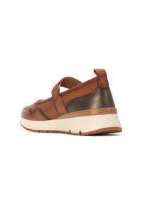 Zapato de cuero marrón con un acento metálico, correa ajustable, suela acolchada y detalles texturizados. La vista trasera muestra materiales contrastantes.