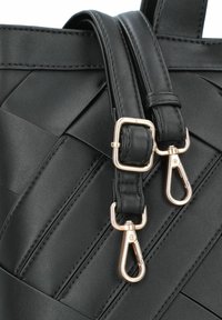 Sac à main en cuir noir avec un design matelassé, doté de quincaillerie dorée, de clips et d'accents cousus sur une surface texturée.