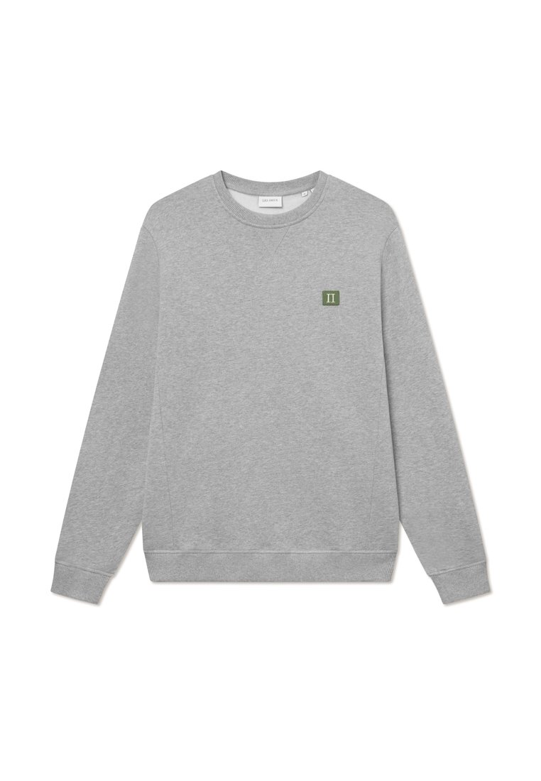 Sudadera gris hecha de una tela suave con cuello redondo, mangas largas, puños de canalé y un pequeño parche de logo verde en el pecho.