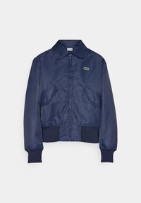 Veste bomber bleu marine zippée avec poignets et ourlet côtelés, poches à rabat, col et petit logo crocodile sur la poitrine gauche.